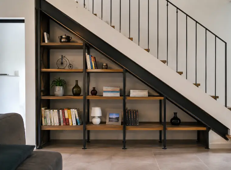 Bibliothèque en fer forgé encastrée sous un escalier